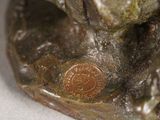 a bronze statue of a dog with a coin in it ' s mouth