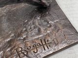 a bronze statue of a bull with a tag on it ' s neck