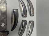 a knife that is laying on a wall next to other knives