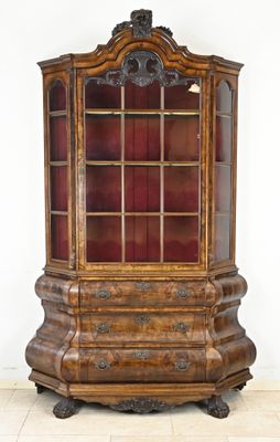 an old wooden display cabinet with a glass door on top of it