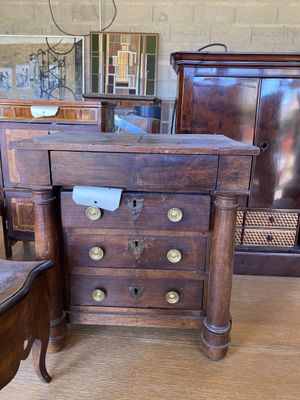 une commode en bois et une chaise dans une pièce