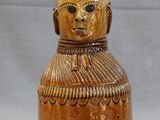 a brown vase with a face on it on a table