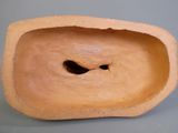 une sculpture en argile représentant un visage percé d'un trou