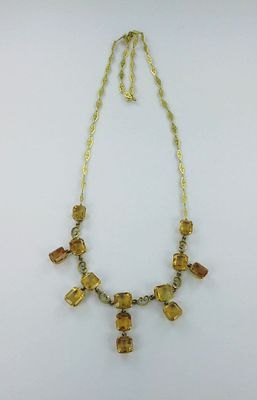 un collier composé de perles de verre jaunes et d'une chaîne en or