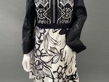 a mannequin wearing a black and white dress with a floral design