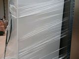 a refrigerator that is wrapped in plastic and sitting in a warehouse