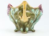 a green vase with a bird on it on a white background