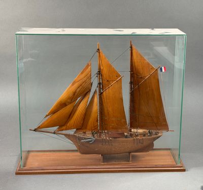 maquette en bois d'un voilier, présentée dans une vitrine posée sur un socle en bois