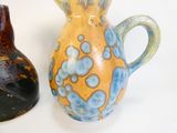 two vases sitting next to each other on a white surface