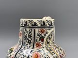 un vase avec un motif floral posé sur une table