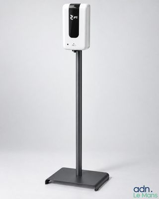 une enceinte noire et blanche est posée sur une surface grise