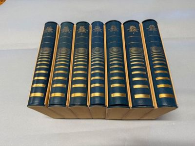 six livres bleus dans une boîte posée sur une nappe blanche