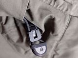 close up of the zipper of a jacket with a small button on it
