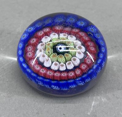 une photo d'une perle de verre ornée d'un motif rouge, blanc et bleu