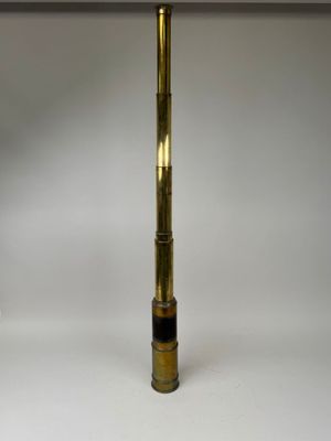 an antique brass telescope on a white surface with a white background