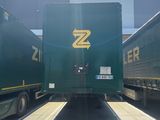 two green semi trucks parked next to each other in a parking lot