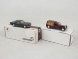 two toy cars sitting next to each other on top of a box
