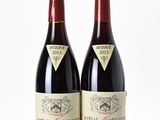 two bottles of wine sitting next to each other on top of a table