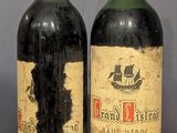 two bottles of wine sitting on top of a wooden table next to each other