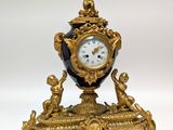 a gold and black clock sitting on top of a table
