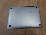 the back of a silver laptop sitting on top of a wooden floor