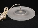 a candle that is sitting on a plate with a cord