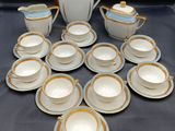 de nombreuses tasses et soucoupes posées sur une table, avec une théière