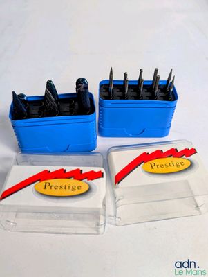 trois boîtes en plastique contenant des stylos, posées sur une surface blanche