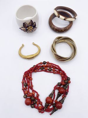 many different bracelets and rings on a white surface