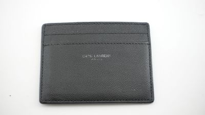 un porte-cartes en cuir noir posé sur une table blanche