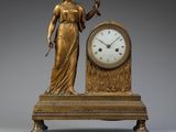 a statue of a woman holding a clock on a table