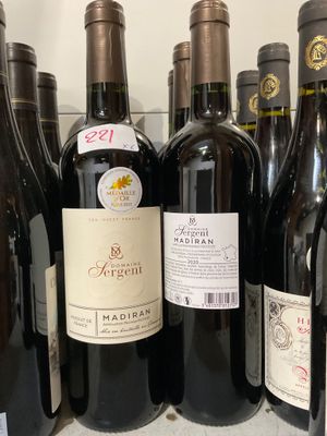 des bouteilles de vin sont alignées sur une étagère dans un magasin