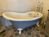 une baignoire avec un panier au milieu, dans une salle de bains