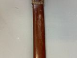 an old wooden stick with a metal handle on a white surface