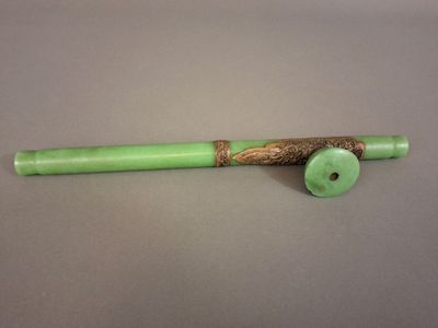 a close up of a green pipe with a wooden handle