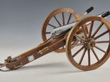 un petit canon en bois auquel est attachée une longue chaîne