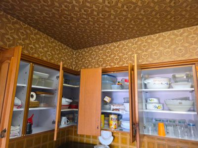une cuisine avec des placards en bois et un plafond carrelé