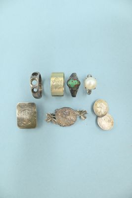 some silver and gold jewelry on a blue surface
