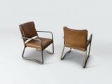 two brown leather chairs sitting next to each other on a white surface