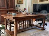 une grande table en bois au milieu d'un salon