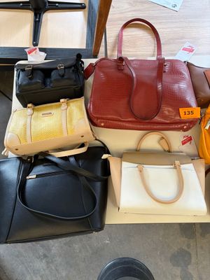 a lot of purses that are sitting on a table