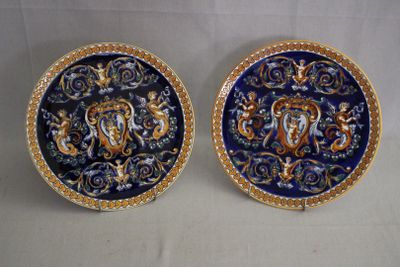 paire d'assiettes décoratives bleues et dorées représentant un lion et une tête de lion