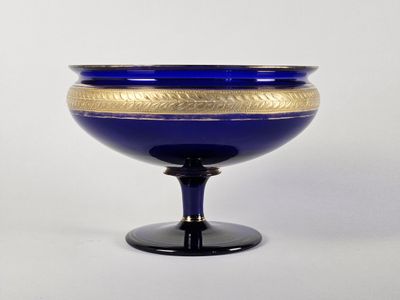 un bol en verre bleu orné d'un motif doré