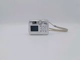 a small silver camera on a white surface