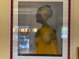 une photo d'une femme en robe jaune accrochée au mur
