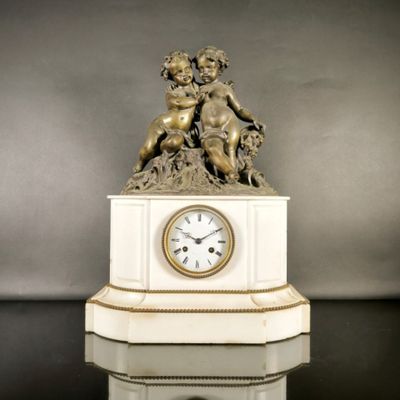 une statue représentant un garçon et une horloge posée sur un socle