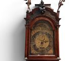 a wooden grandfather clock with angels on top of it