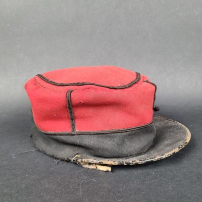 un chapeau rouge orné d'un ruban noir