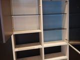 a white bookcase with glass shelves in a room