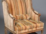 une vieille chaise dont le dossier rembourré a été décapé et dont la structure est en bois